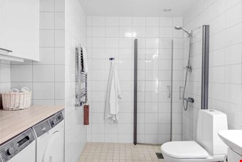 Helkaklat badrum med tv�ttmaskin och torktumlare.
